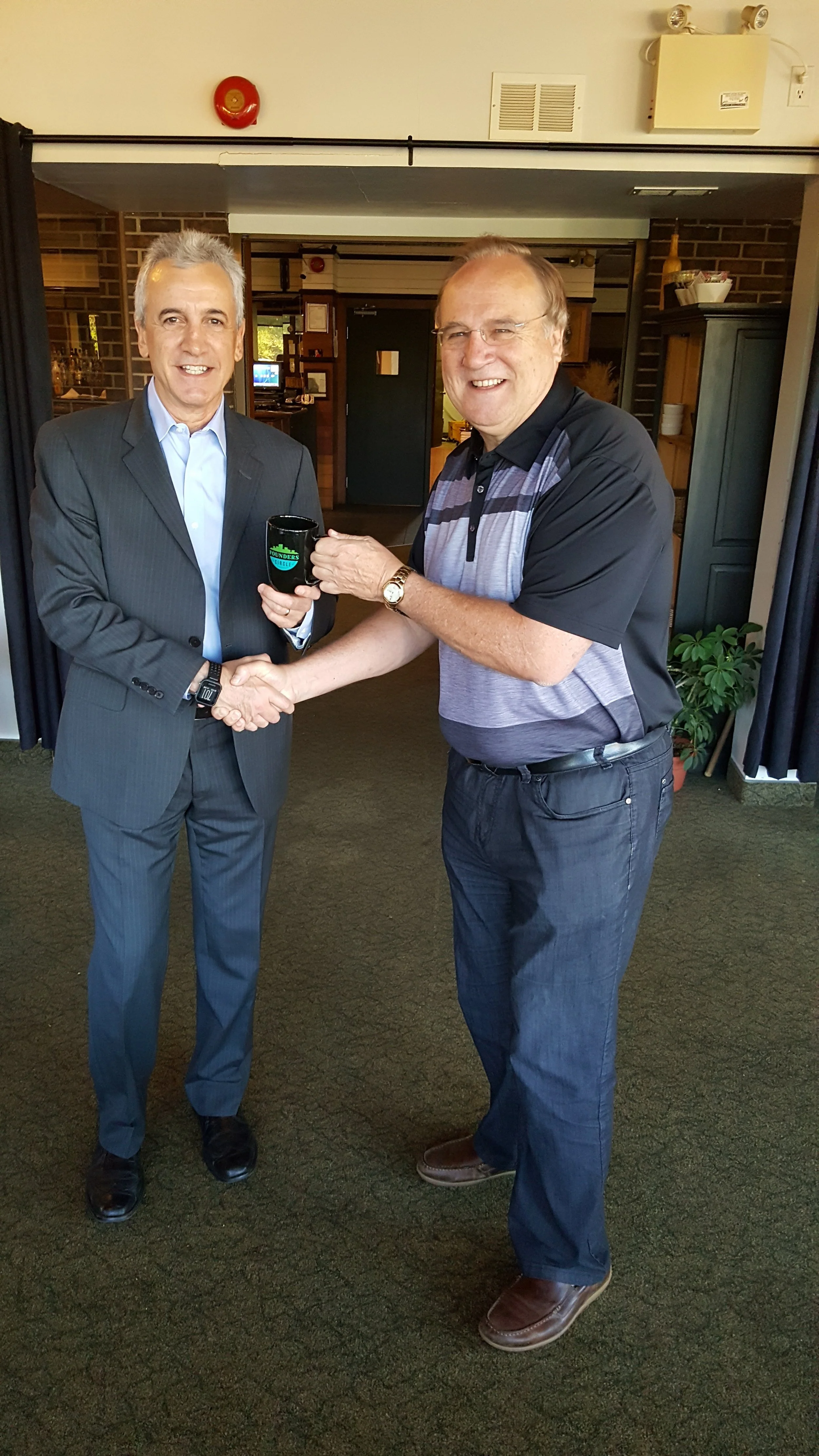 Stuart Morley presenting the Founders Circle mug fo Rick Dalmazzi