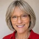 Author Lorri Devlin, with ash blonde hair, glasses, and a warm smile, wearing a red top.