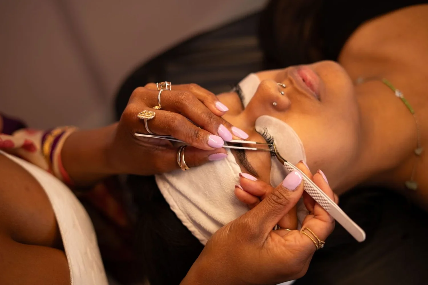Lash artist applying lash extensions with tweezers