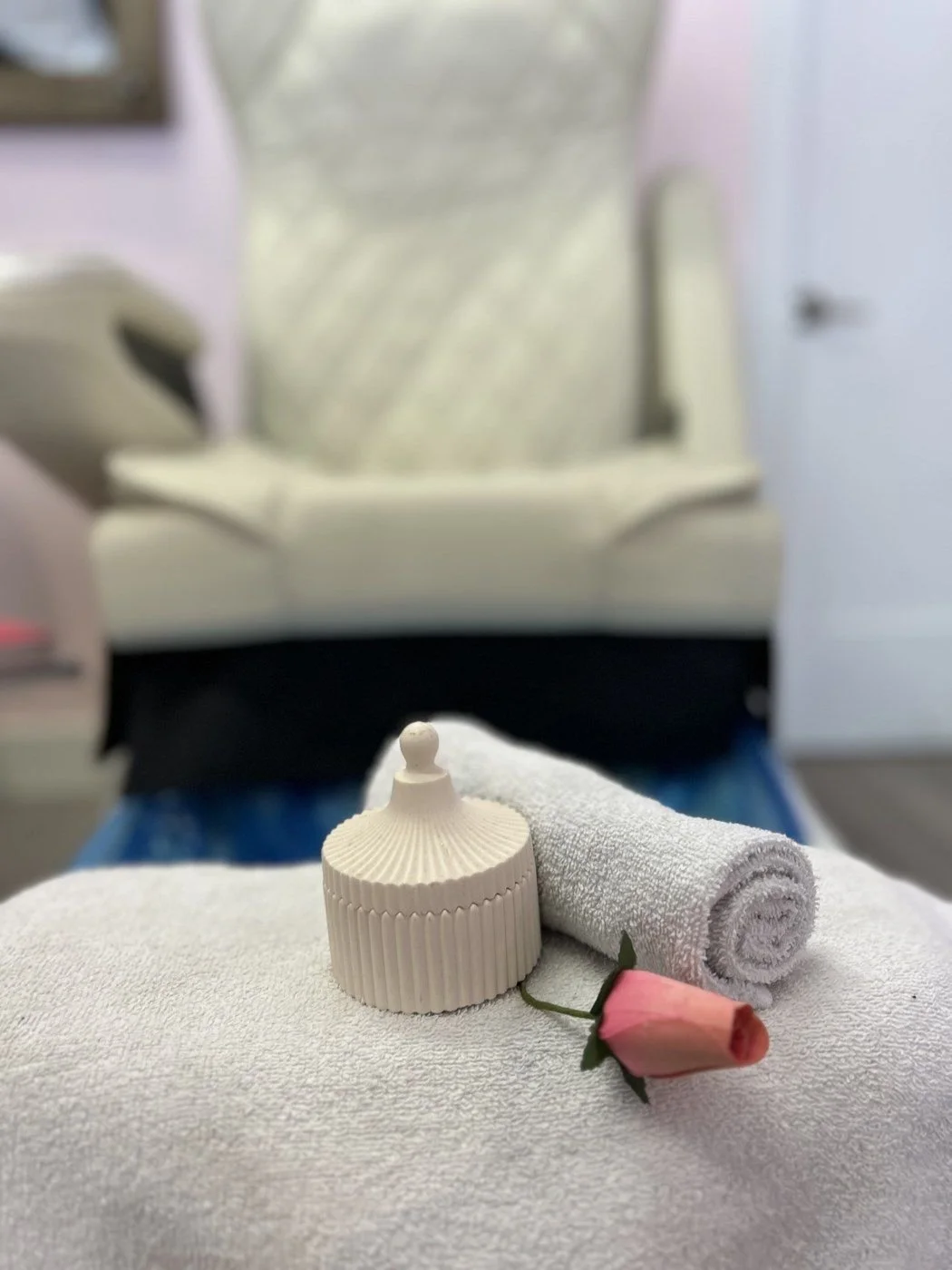 Dollface pedicure chair with a rolled towel and a pink rose