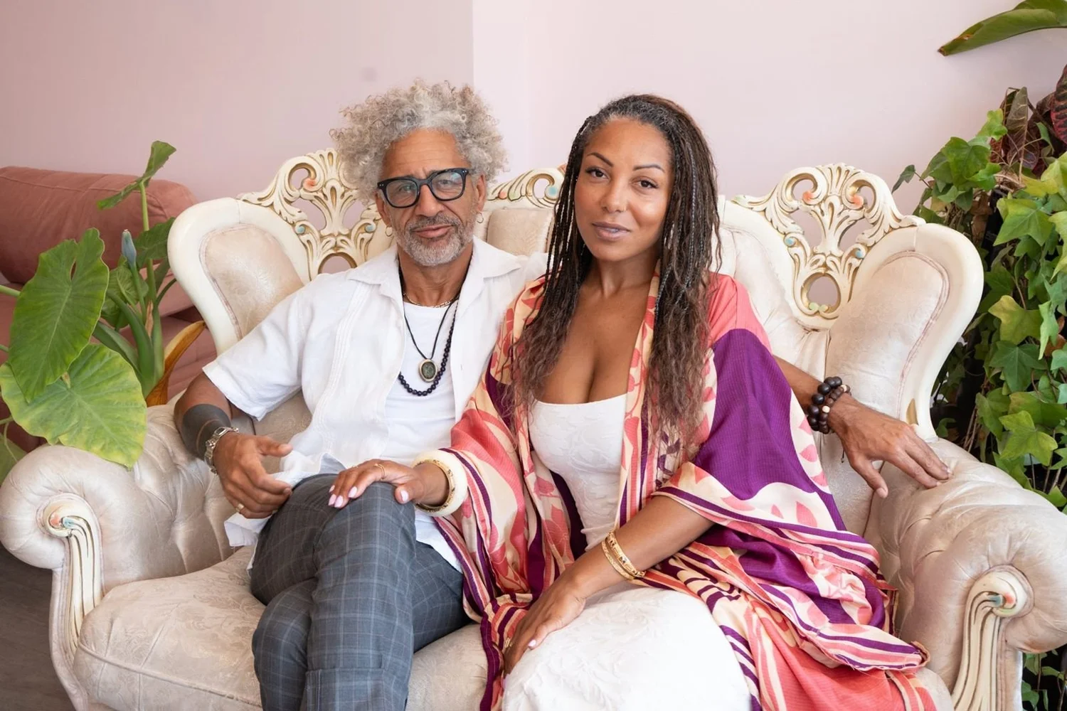 Dollface founders seated together on a tufted settee in the salon