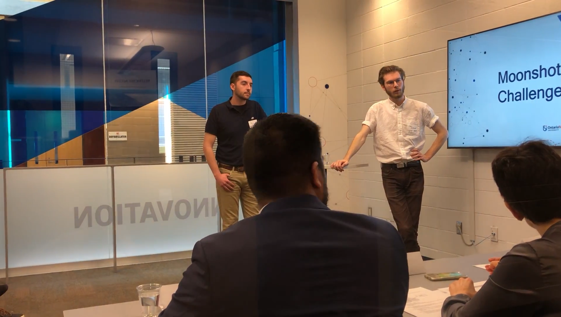 Two students pitch their moonshot to Lorenzo and the panel.