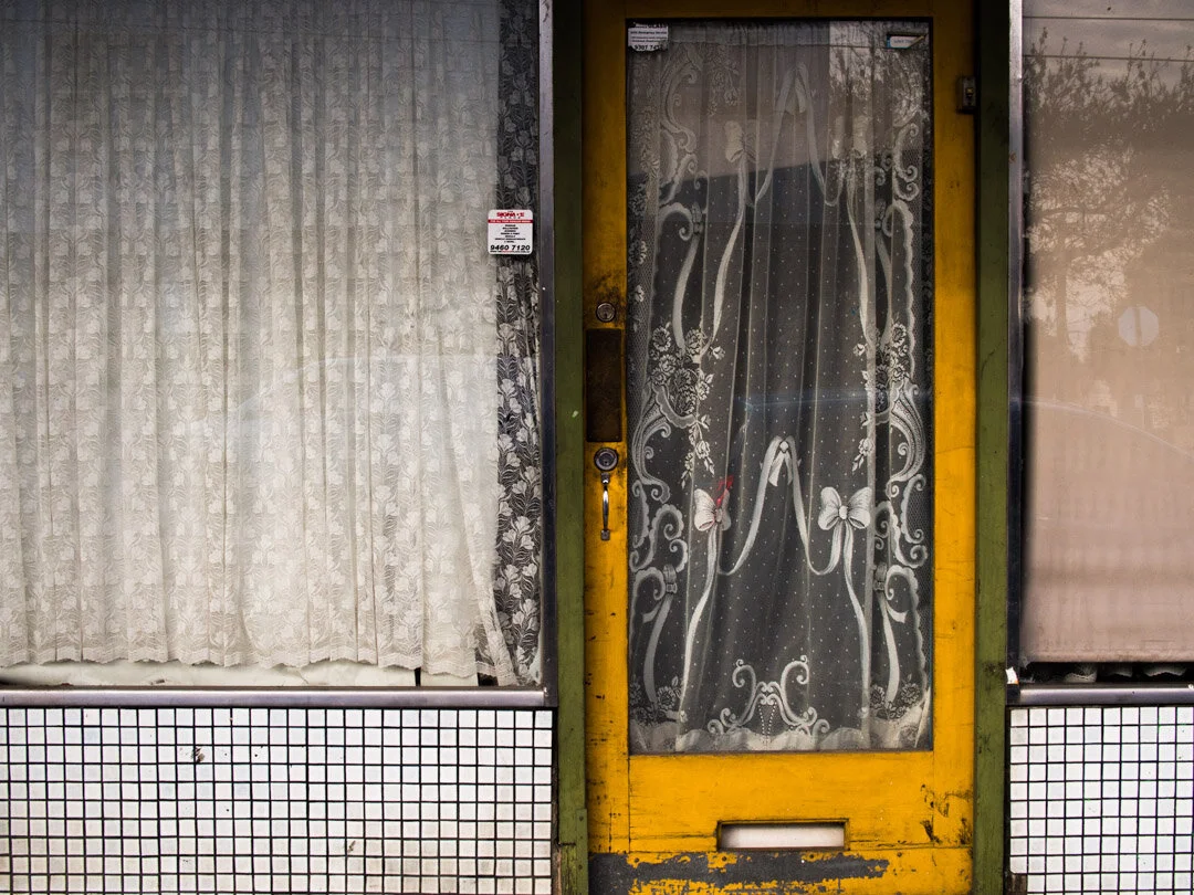 Walks around the neighbourdood. My eye is drawn to the front of old shops that are 'no more shops'. Tiny white tiles that frame large display windows now filled with grubby curtains. #thornbury