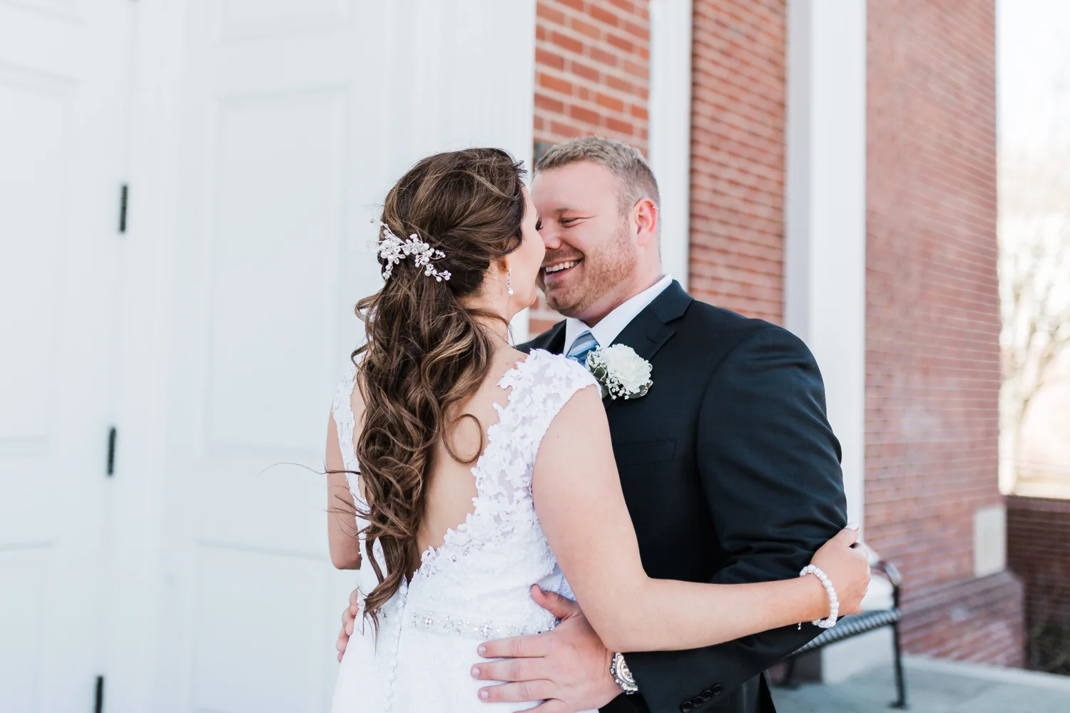 Bride and groom smiling after seeing each other for the first time during their first look at McDaniel College