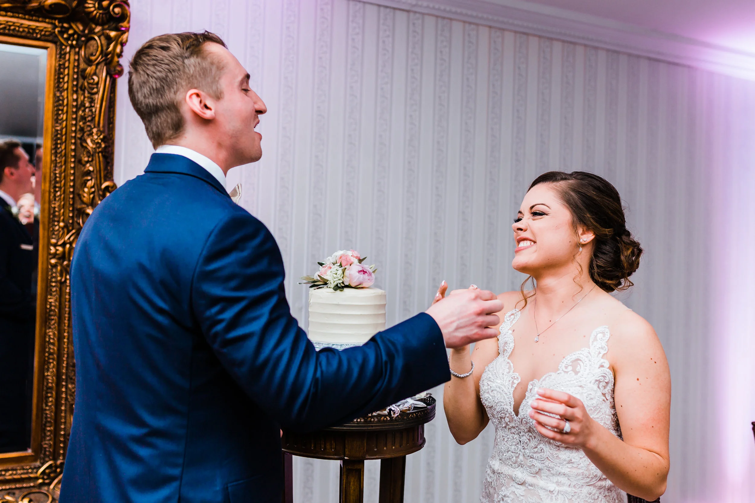 bride and groom laughing after feeding each other cake that their carroll county maryland wedding - photographer