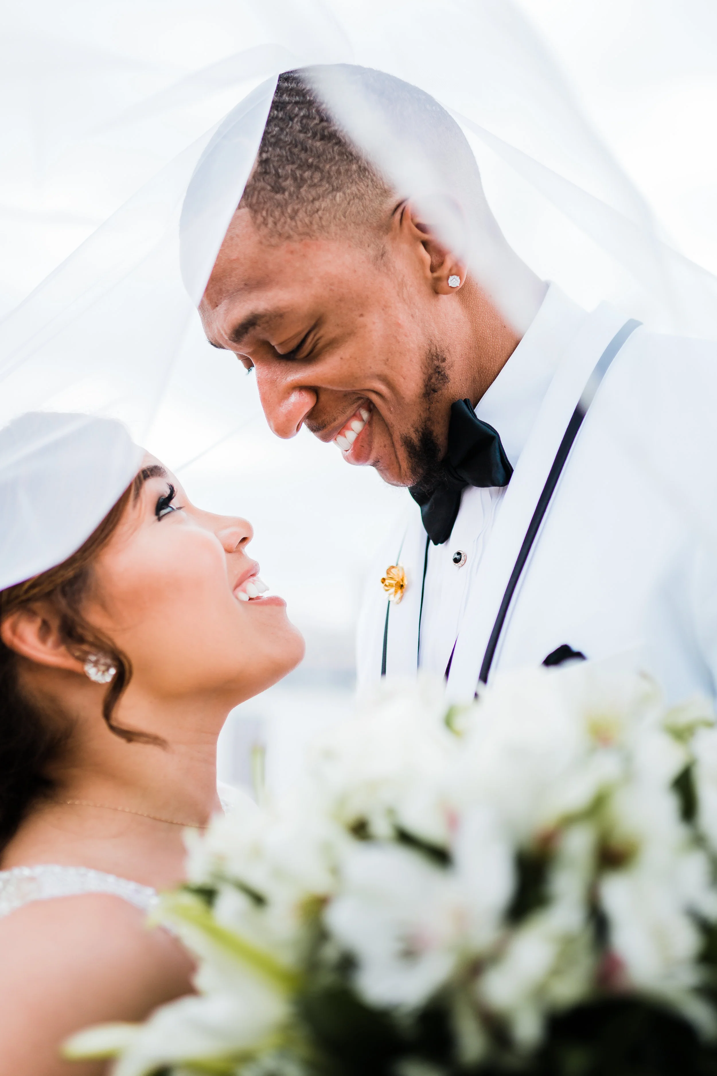 bride and groom share an intimate moment under her veil