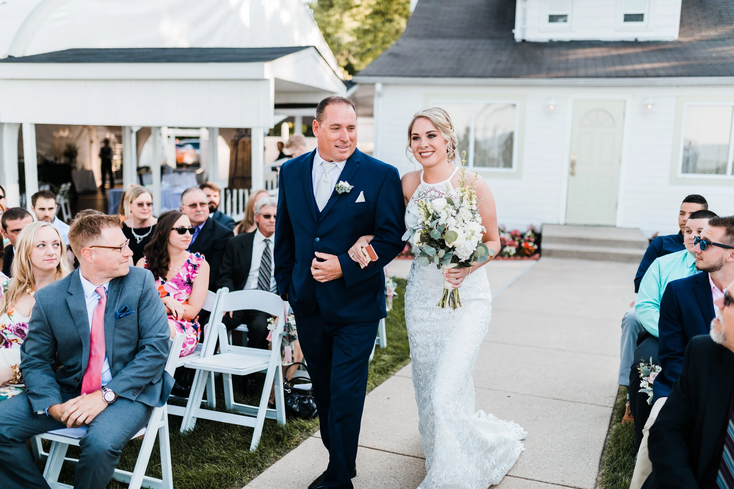 bride walking down the aisle with her father in high neck wedding dress with silver dollar eucalyptus bouquet at pasadena maryland wedding