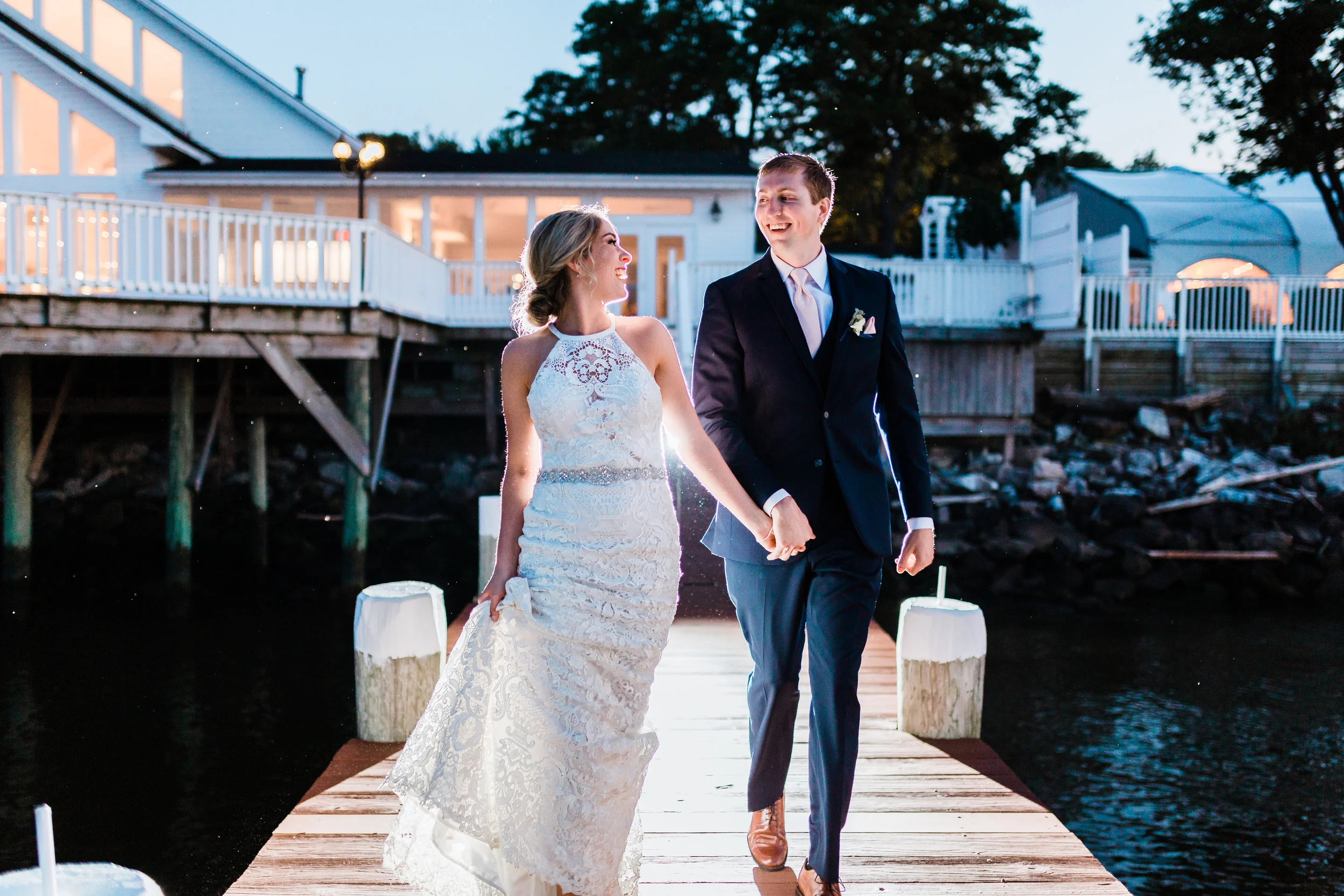 bride and groom running and laughing together - celebrations at the bay - best maryland wedding photographer