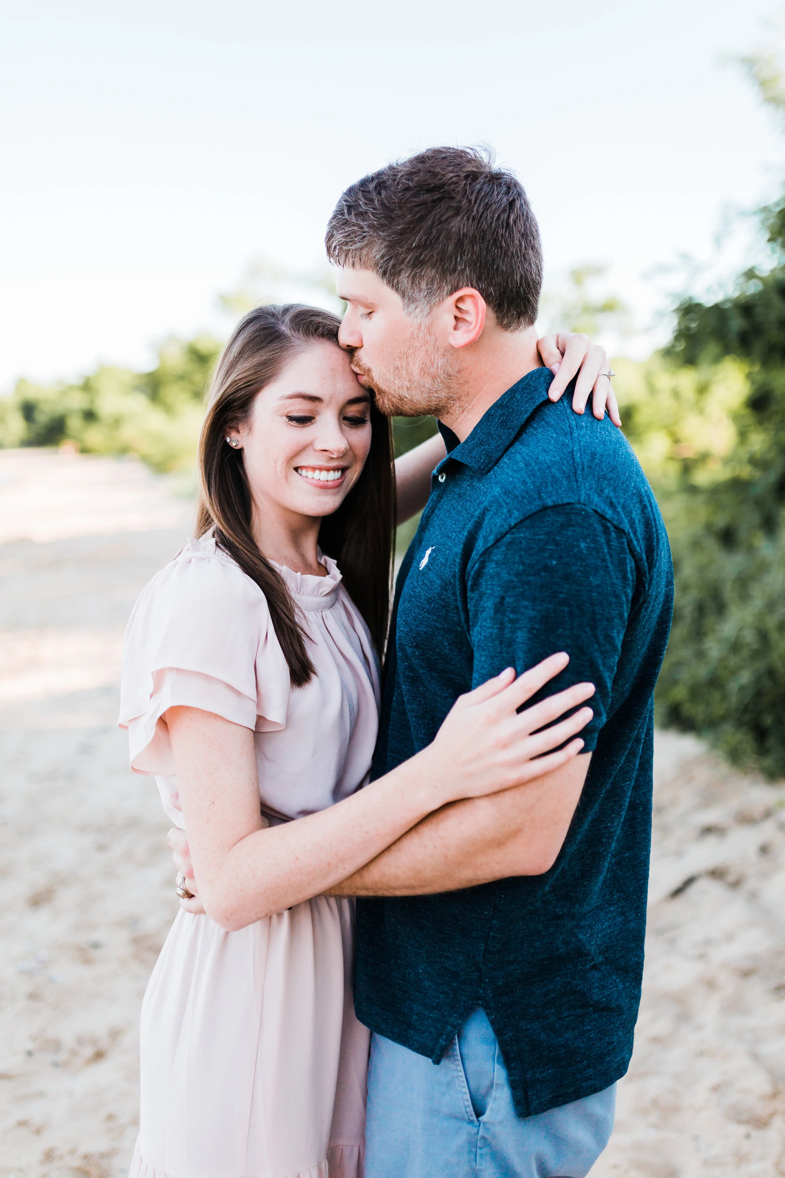 couple embracing on beach in pasadena md - maryland wedding and engagement photographer