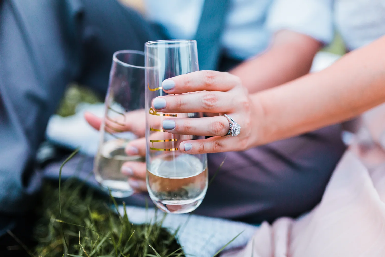 champagne toast engagement session in vineyard with stemless wine glasses