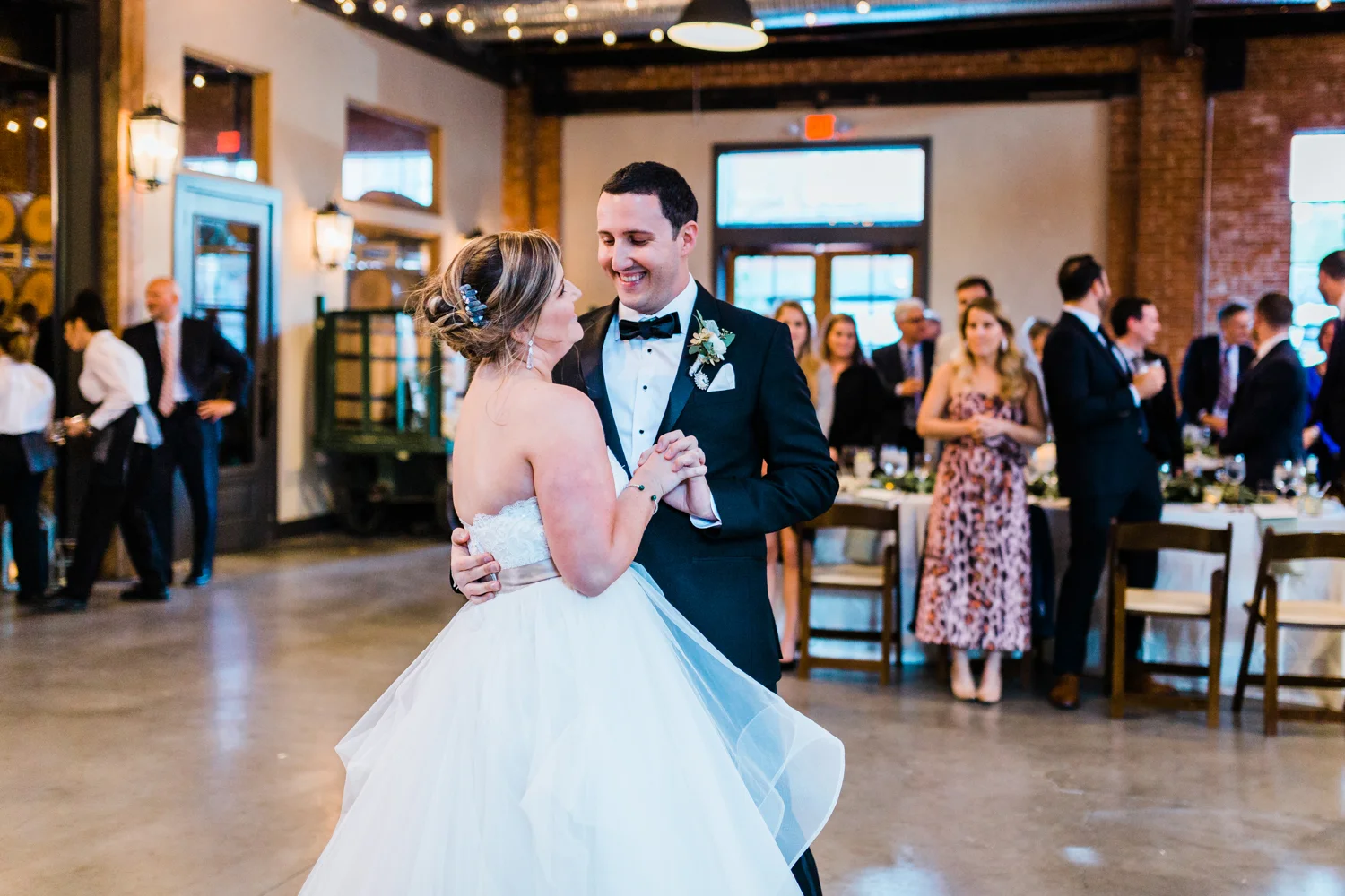 Bride and groom smiling at each other during first dance - top photographer in MD
