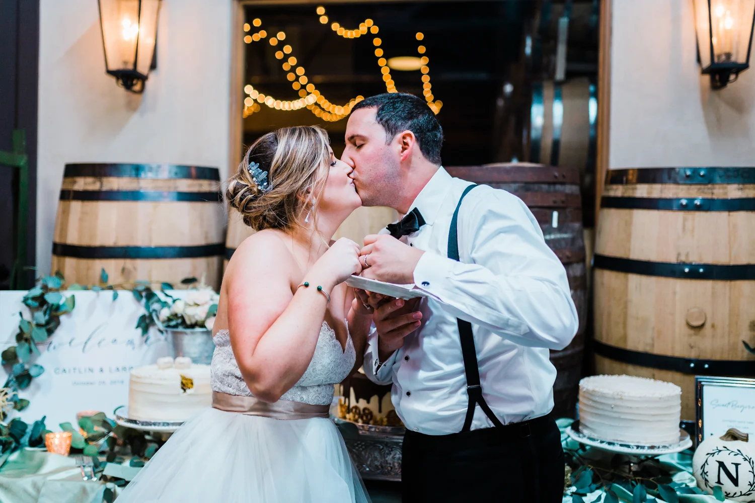 Bride and groom kiss after cutting their wedding cake - candid wedding photographers in Maryland