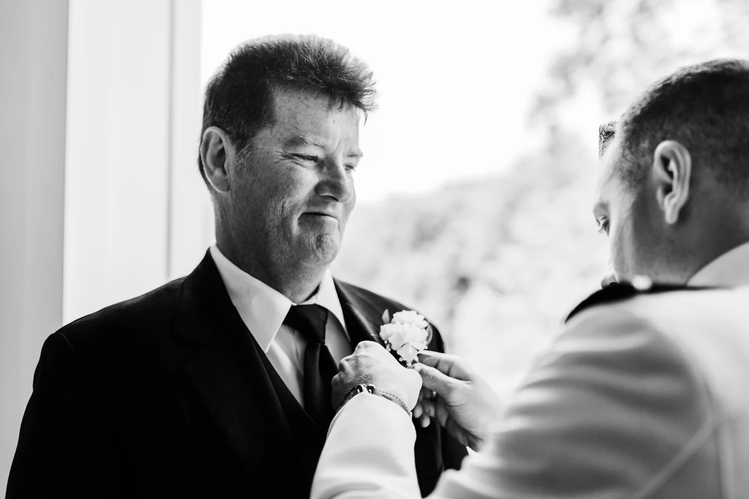groom putting on his dad’s boutonniere - maryland wedding photo and cinematography