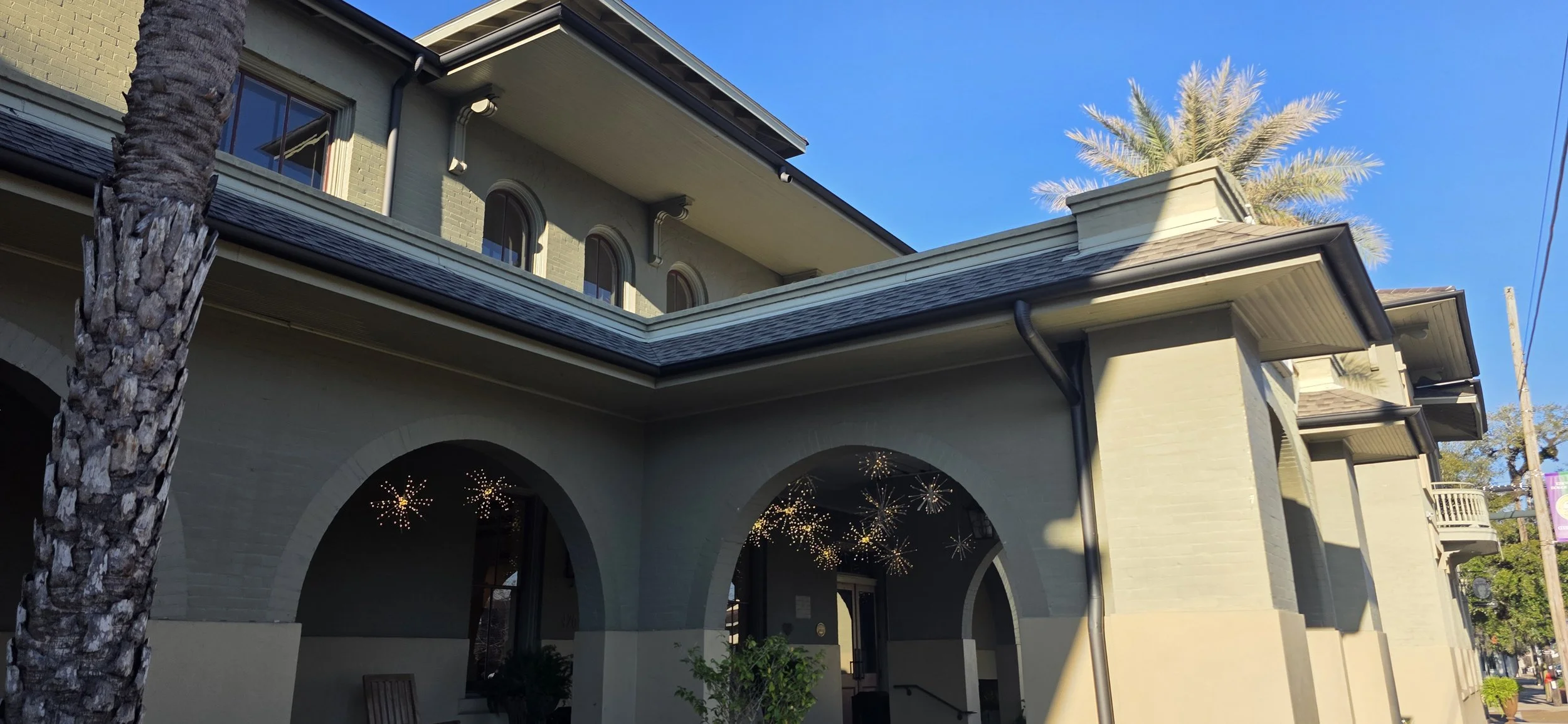 a beige building with lots of arches in the entryway and palm trees out front in Covington, Louisiana
