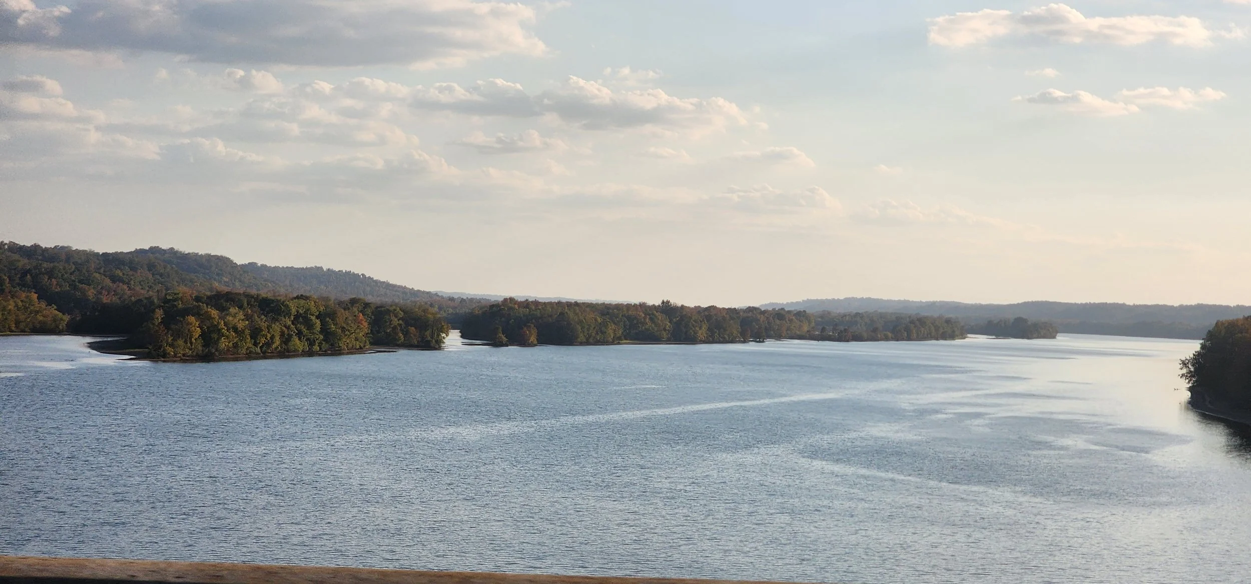 wide river with tree covered ridges and an island as seen from the i-40 bridge