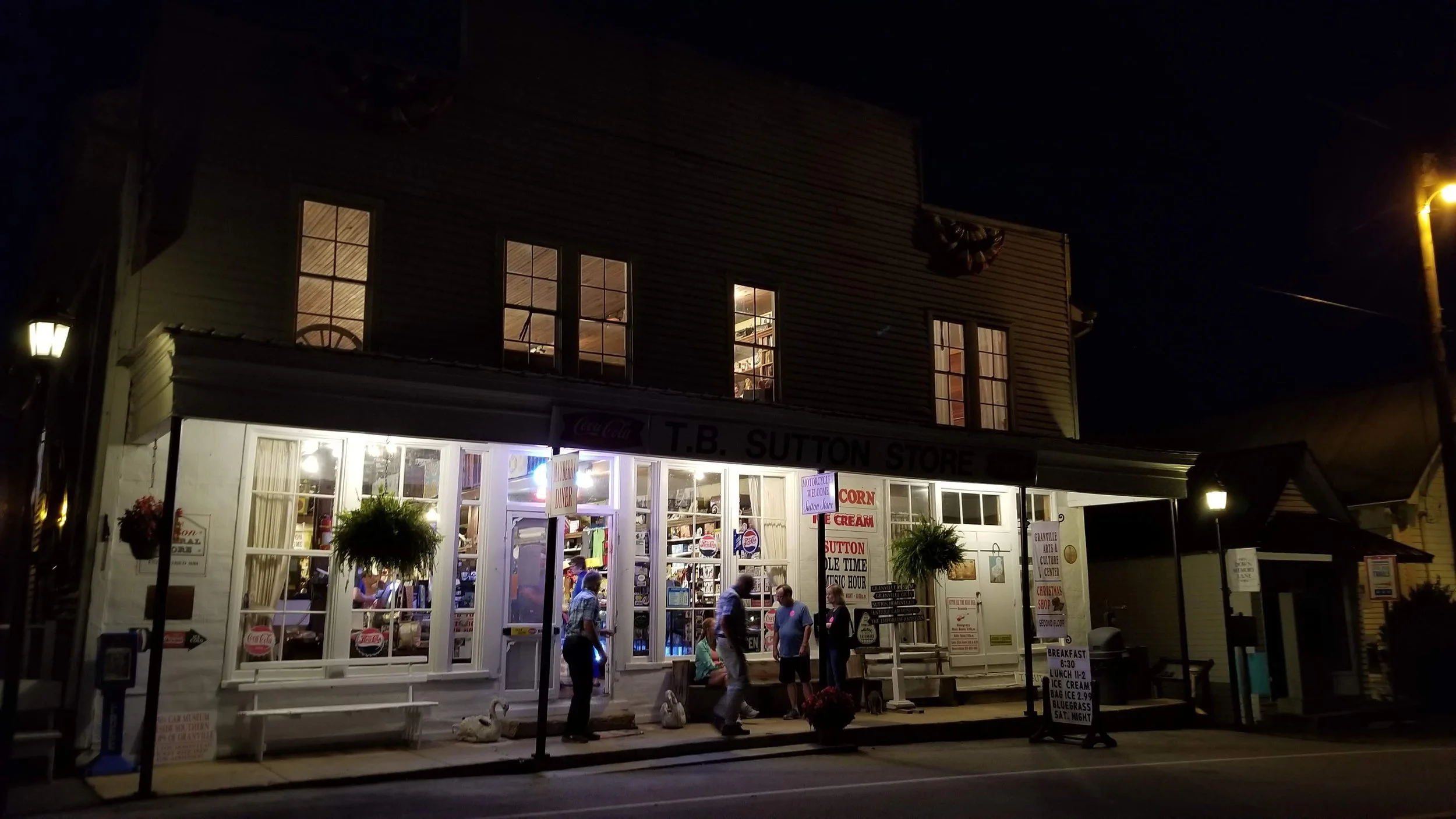 People gather outside an old store at night