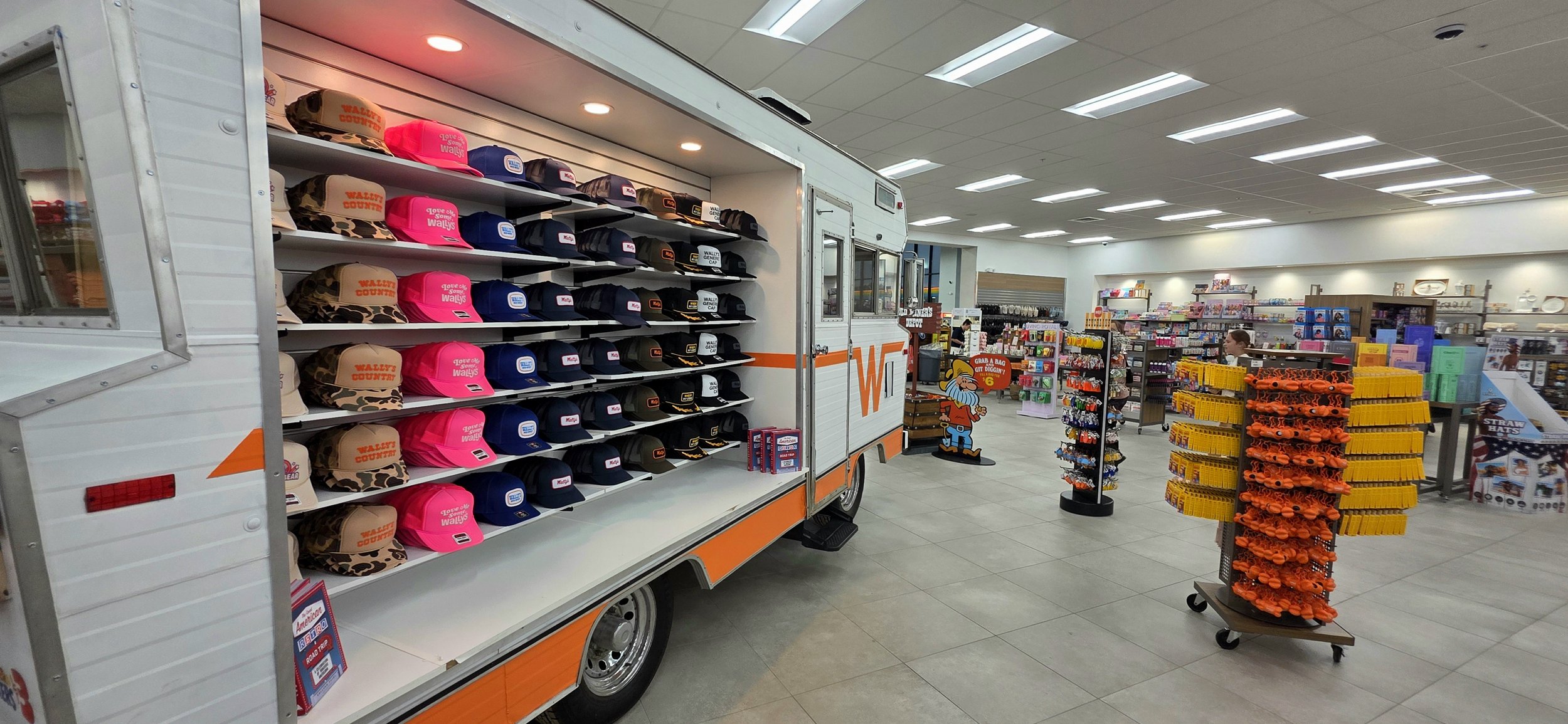 rows of caps line the side of a small winnebego inside a store