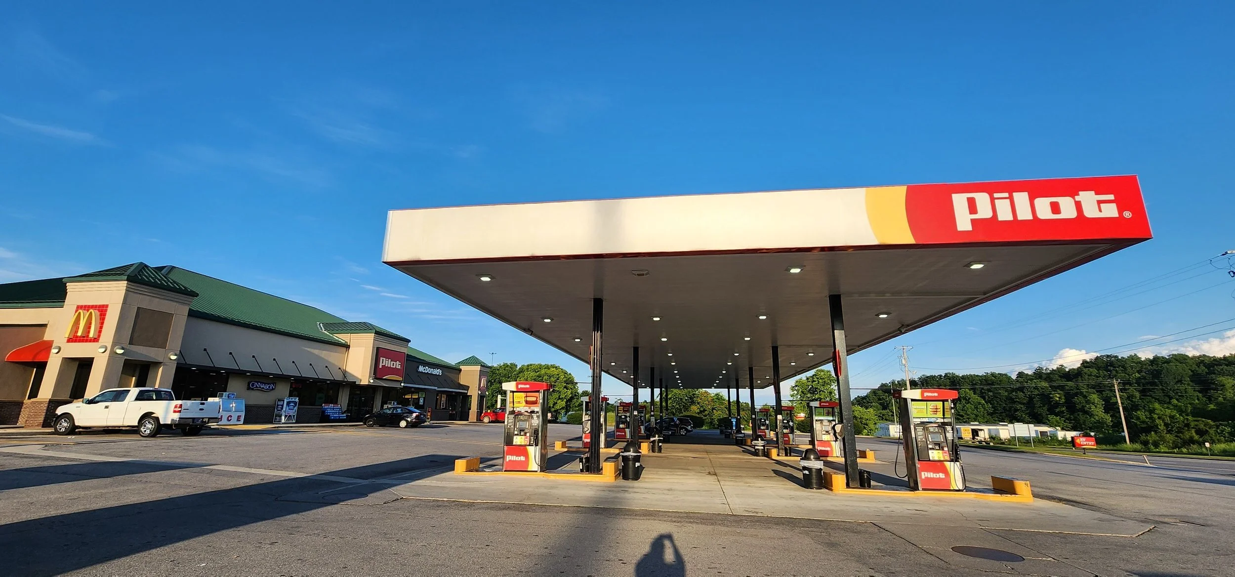 Big awning covering fuel pumps with travel center in the background