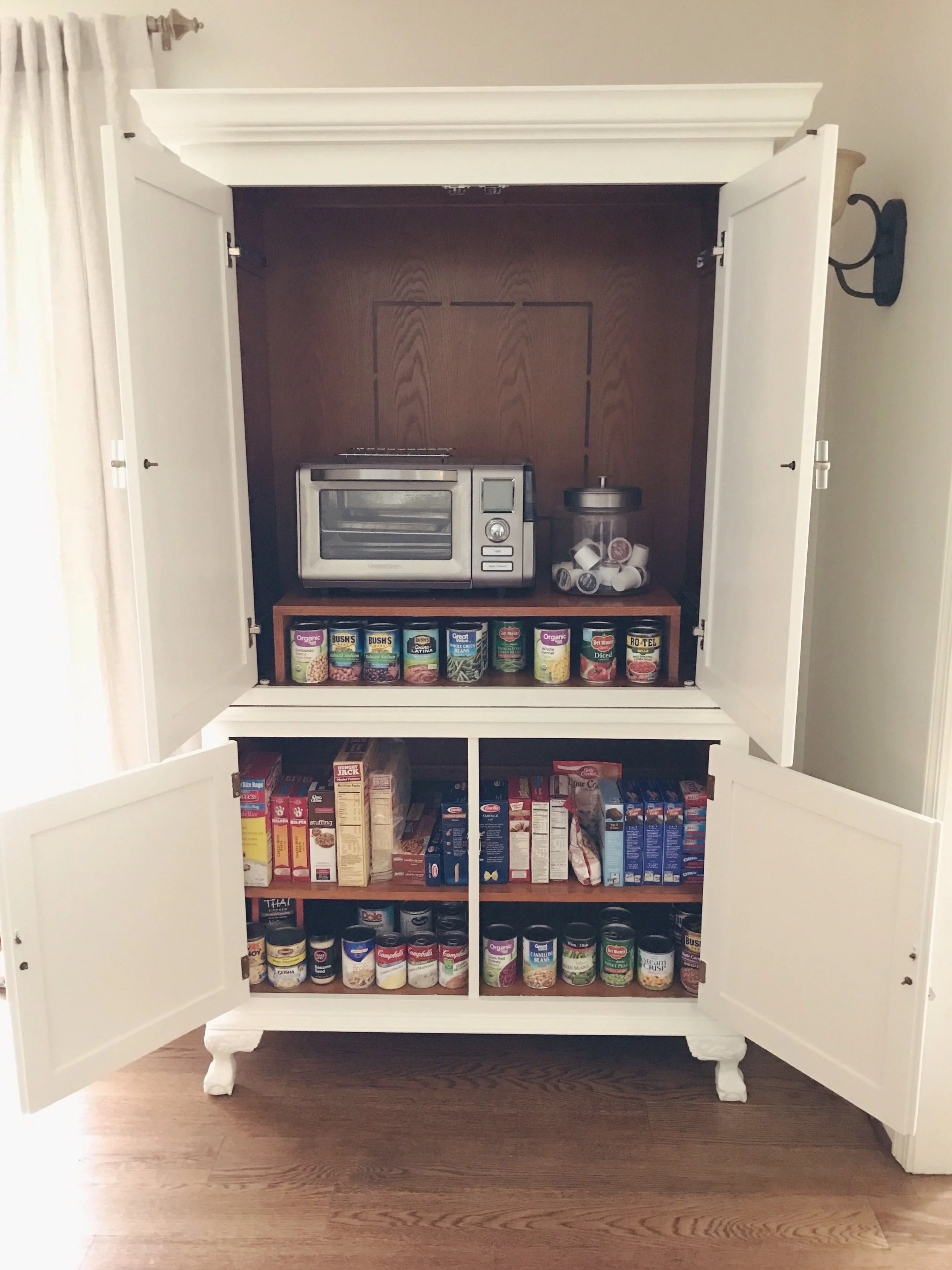 The armoire now holds all of our canned goods and boxed items, and hides our little oven. I have so much more cabinet space and can sort through things easily. Putting up groceries is no longer a pain, or as much of one anyway, haha!