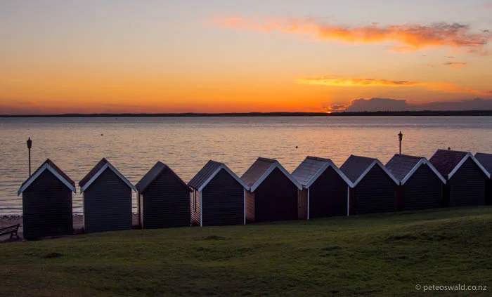 Sunset at the beach huts near Gurnard Sailing Club, traditionally beach huts were used by woman before bathing in the sea
