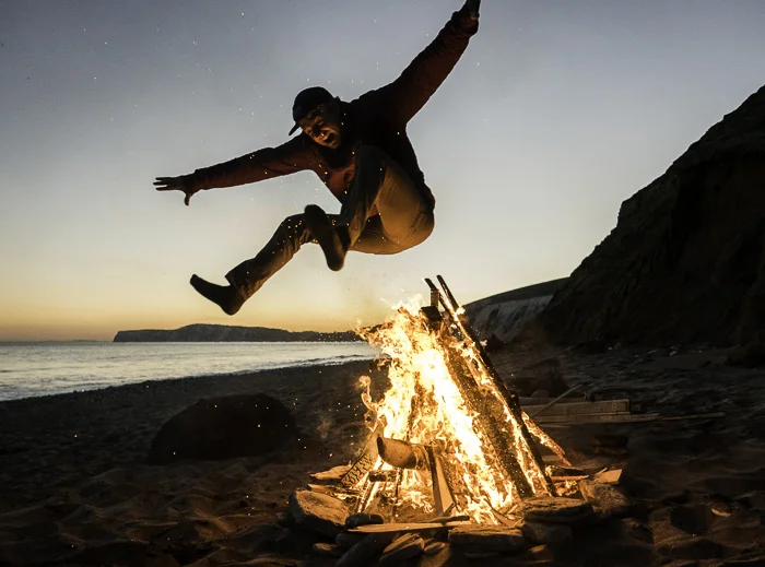 Hamish Smith leaping the fire on Compton beach