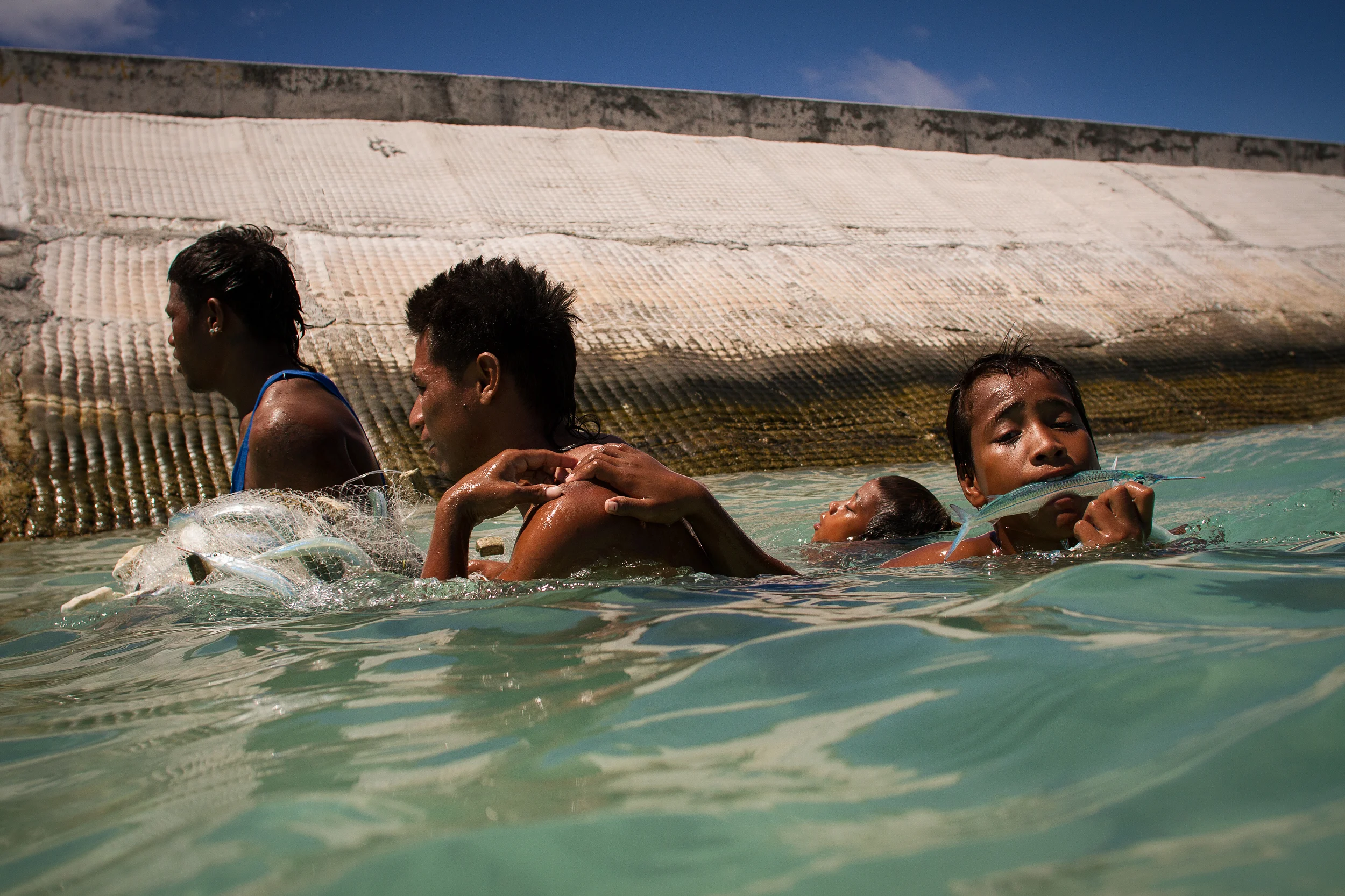 The young men come back to shore on the lagoon side with their catch. Despite firm warnings to travellers not to even wade in the lagoon due to pollution and open defecation, the locals eat the fish from here everyday.
