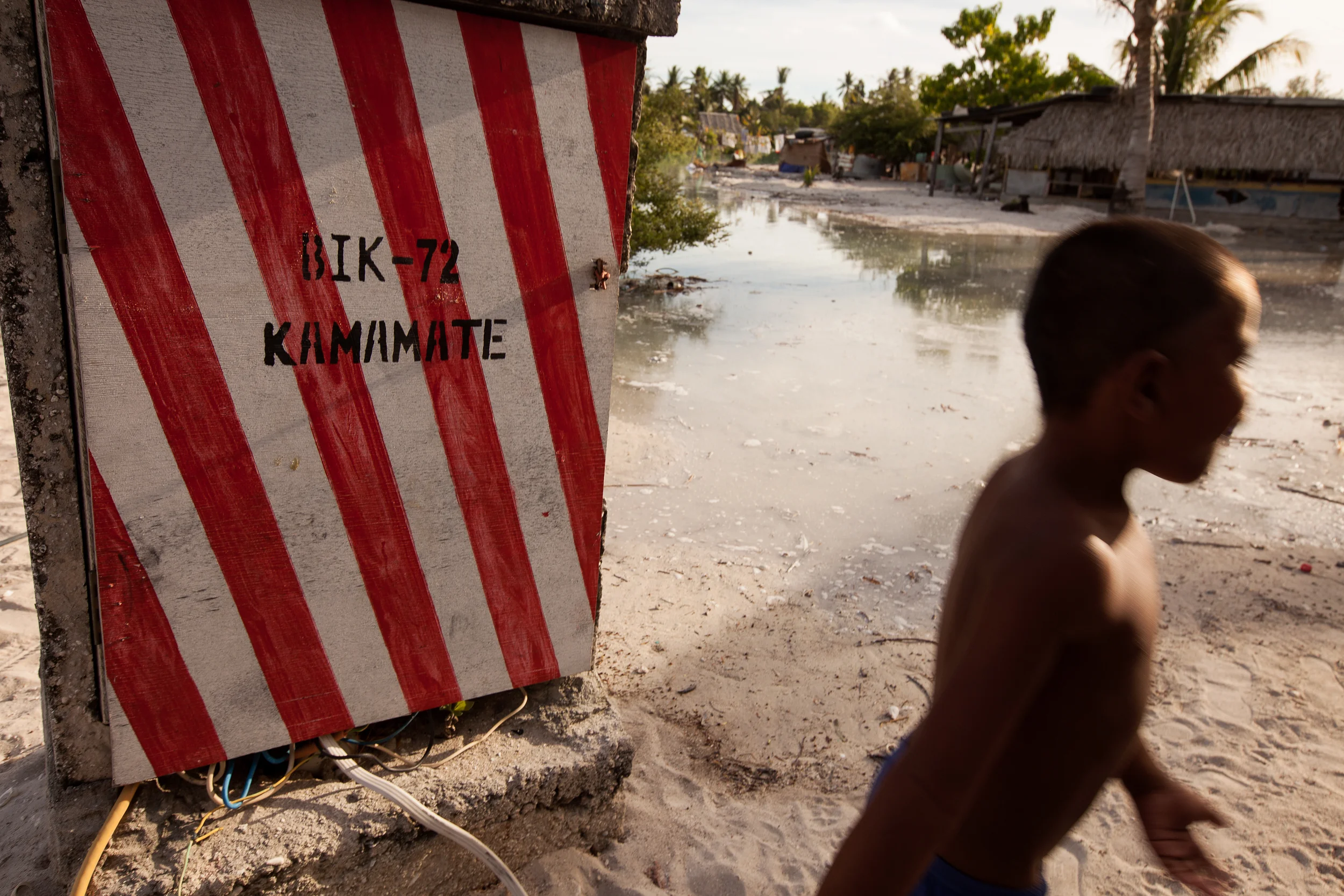 A young boy walks in front of a power box in Golden Beach as the tide fills in toward the wires. Last year a nearby box exploded when the water made contact with the wires.