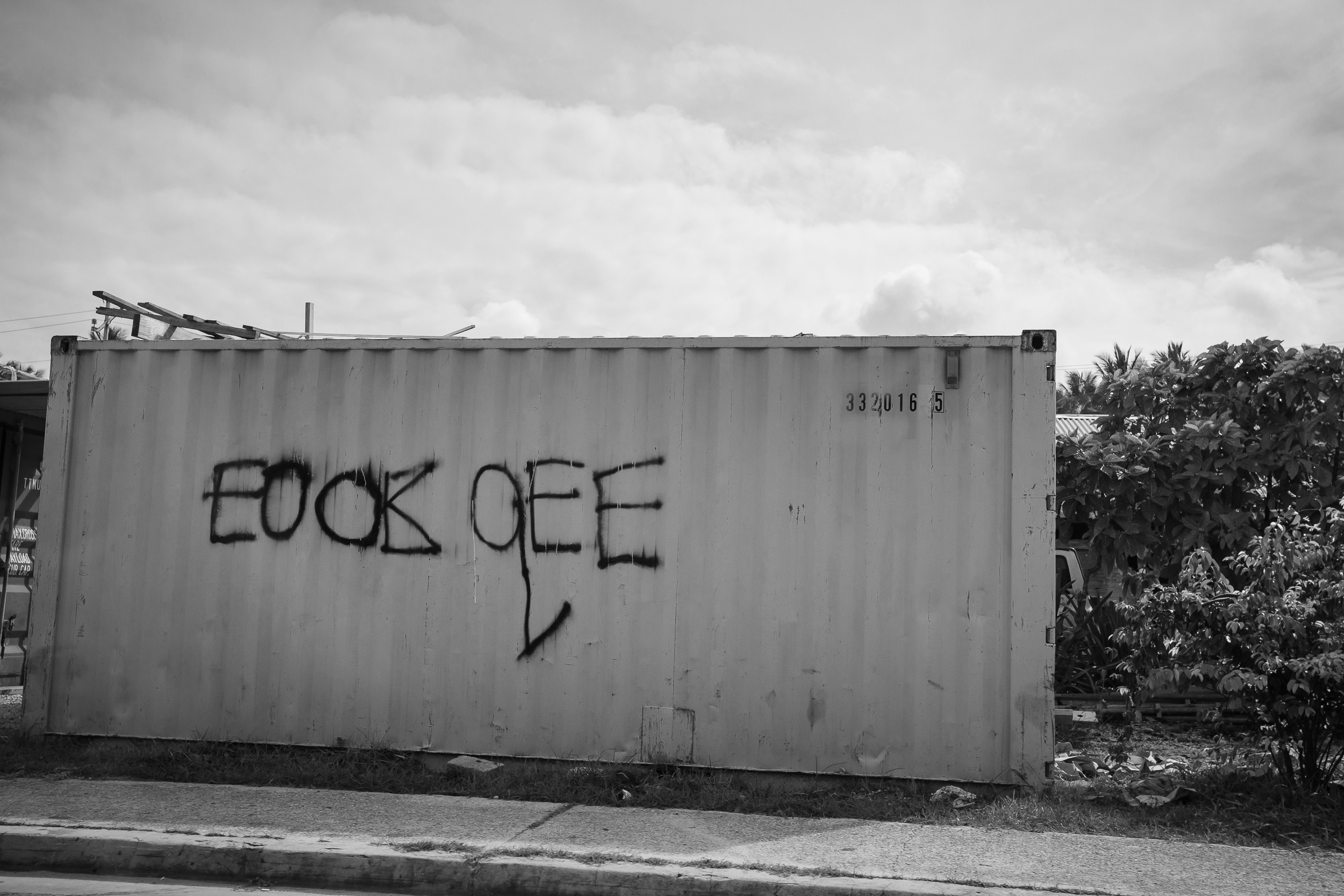 Graffiti scrawled on the side of a shipping container has been altered afterwards in an attempt to hide the original meaning. There is strong animosity directed at the refugees from some of the locals who do not want the refugees on Nauru.