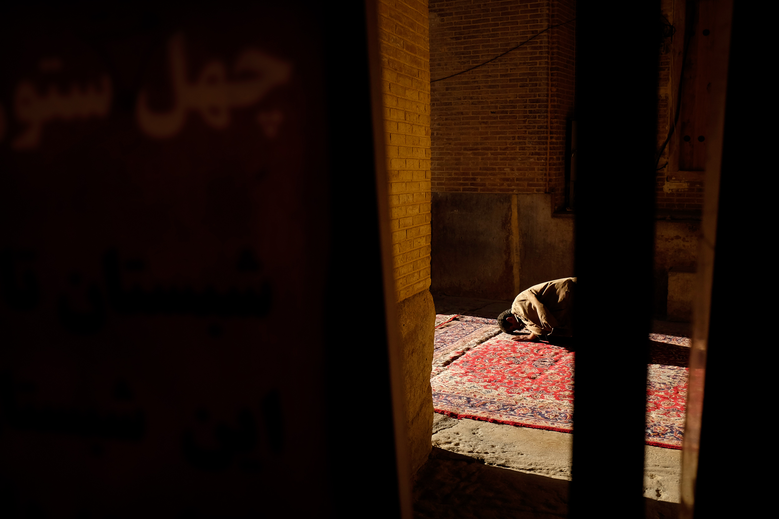A man prays towards the setting sun in a mosque in Shiraz.