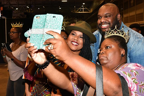 John and Aventer Gray stop to pose for a photo with a fan at Essence Fest (Credit: Paras Griffin/Getty )