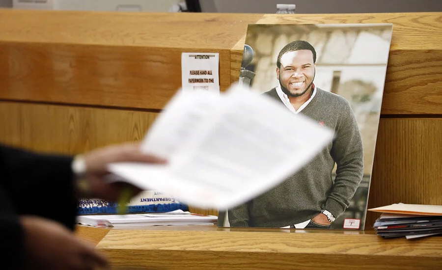 A photo of victim Botham Jean leans against Judge Tammy Kemp’s bench reminding everyone of the life needlessly taken (Credit: Tom Fox/Associated Press)