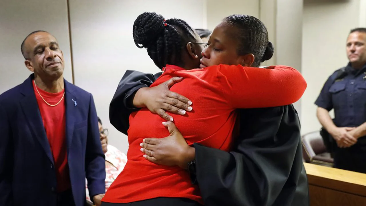 Judge Tammy Kemp gives Botham Jean's mother, Allison Jean, a hug while Botham's father, Bertrum Jean, looks on. (Tom Fox/The Dallas Morning News via AP, Pool)