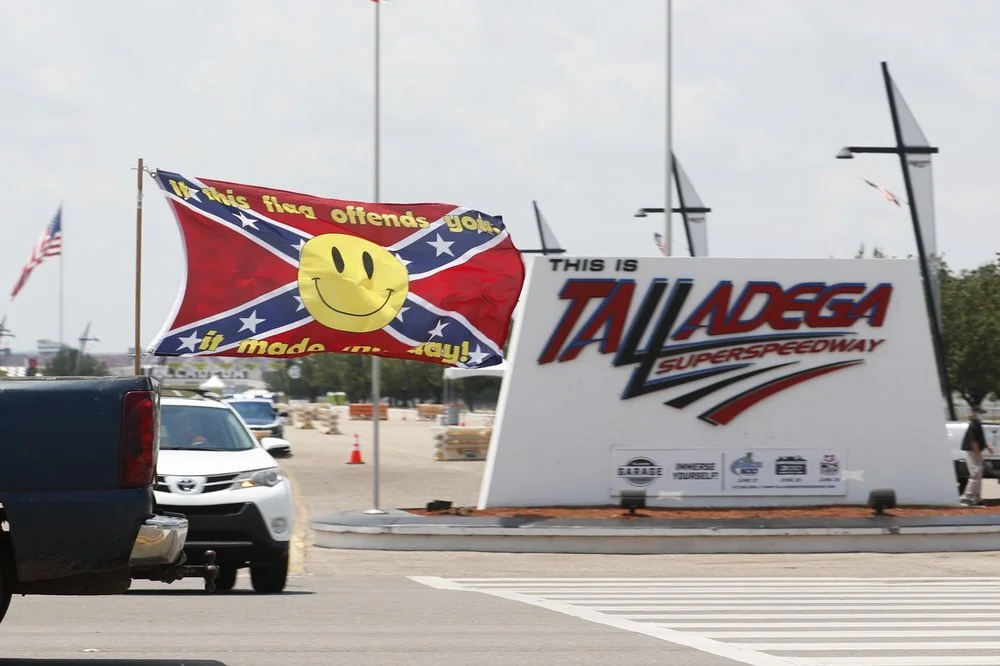 Race fans fly Confederate battle flags and United States flags as they  drive by the entrance to Talladega Superspeedway prior to a NASCAR Cup  Series auto race in Talladega Ala., Sunday, June 21, 2020. (AP  Photo/John Bazemore)