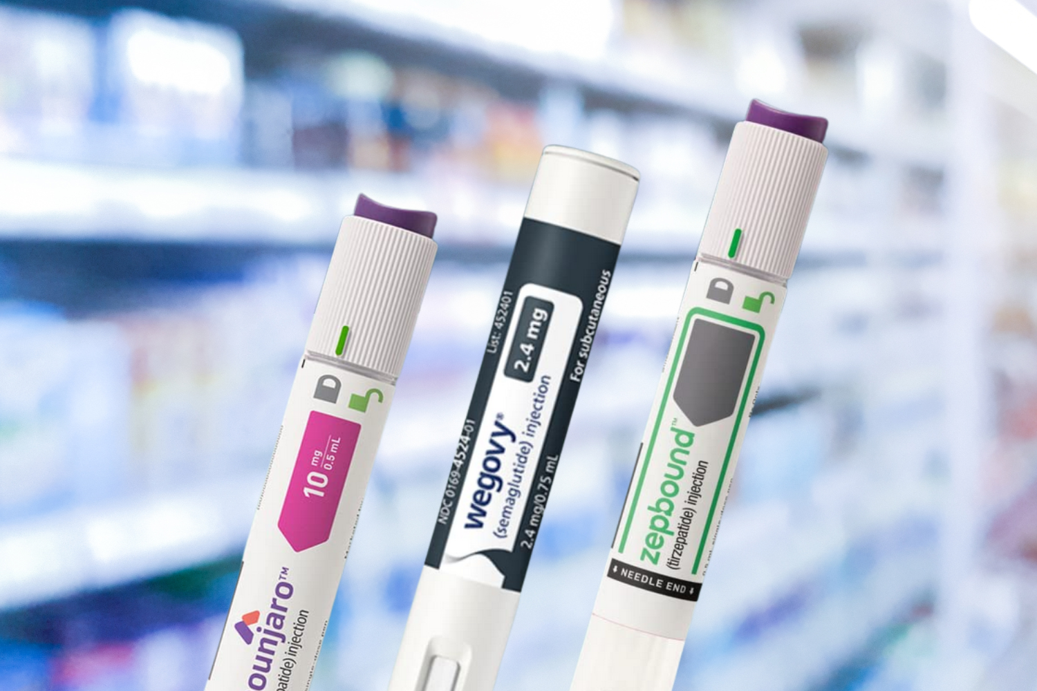 Three injection pens labeled Mounjaro, Wegovy and Zepbound against a blurred background of pharmacy shelves.