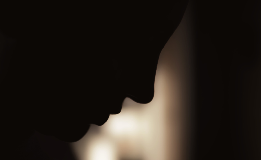 A woman's face in shadowed silhouette with her head bowed, illustrating the grief and weight of loss when something we depended on falls away