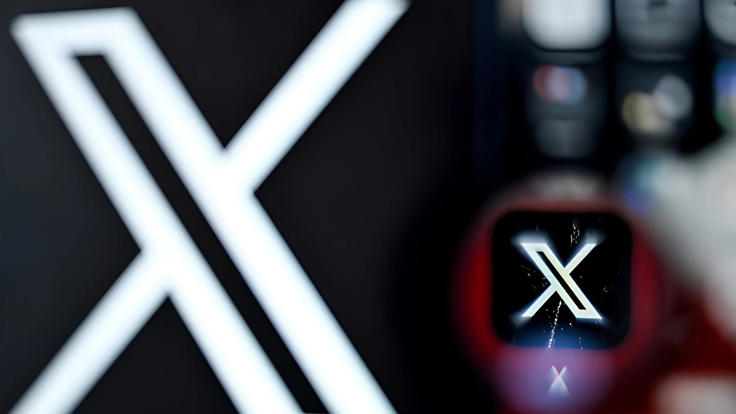 The X logo appears on a dark screen behind a smartphone showing the X app icon.