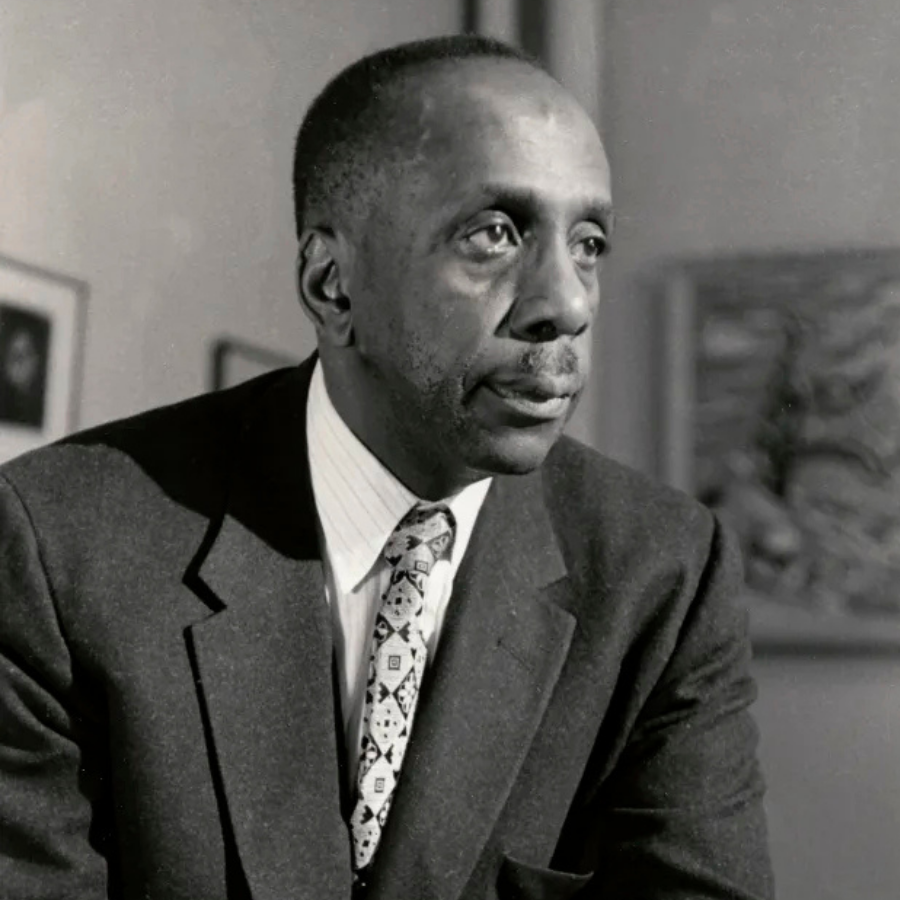 Black and white portrait of Howard Thurman, theologian and author whose work influenced the civil rights movement, wearing a suit and patterned tie