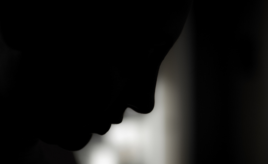 Silhouette of a woman with her head bowed, conveying emotional strain during a season of waiting.