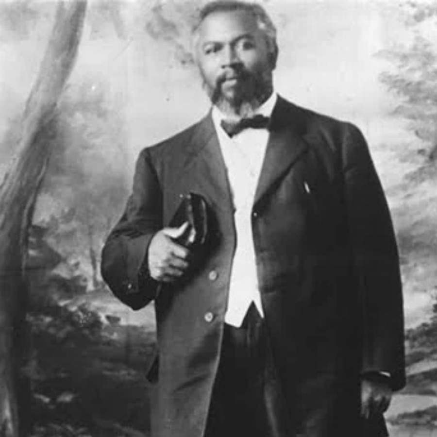 Historical black and white portrait of William J. Seymour, Pentecostal preacher and leader of the 1906 Azusa Street Revival, holding a Bible in formal attire