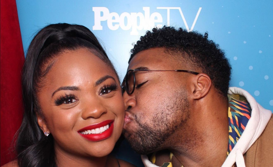 Marlon Moore, known as DJ ASAP, and LaShonda Moore pose together in front of a PeopleTV backdrop
