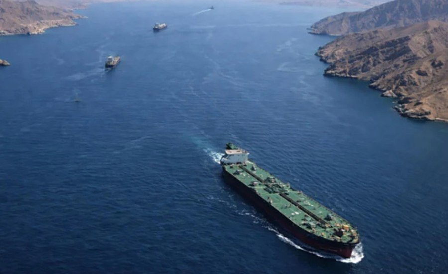 Aerial view of an oil tanker navigating the Strait of Hormuz, with mountainous coastline visible on both sides.