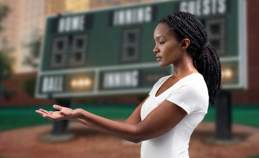 A woman holding out open, empty hands before a blurred stadium scoreboard, illustrating receiving grace rather than earning it
