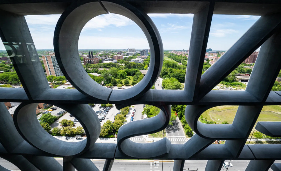 A view of Chicago's Hyde Park and Woodlawn neighborhoods seen through the large sculptural concrete letters on the facade of the Obama Presidential Center museum tower