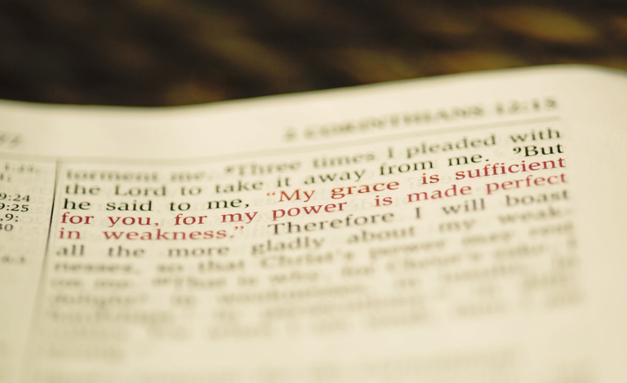 pen Bible showing 2 Corinthians 12:9 in red letters, "My grace is sufficient for thee: for my strength is made perfect in weakness"
