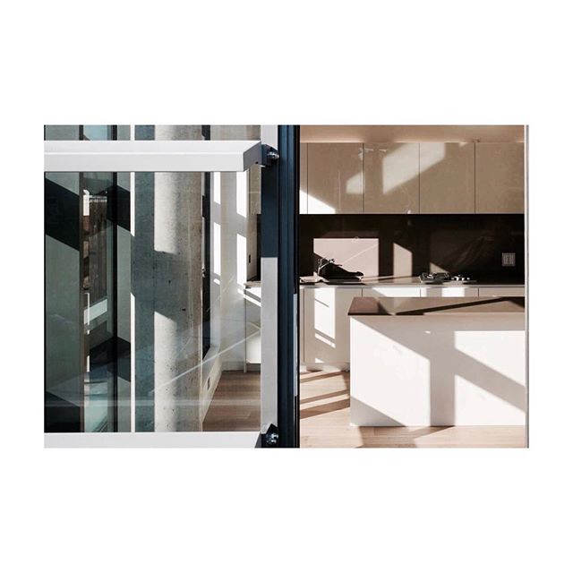 Floor to ceiling glass walls with fins on the facade that cast interesting shadows on this minimal kitchen #shadows #facade #kitchen #light #cast