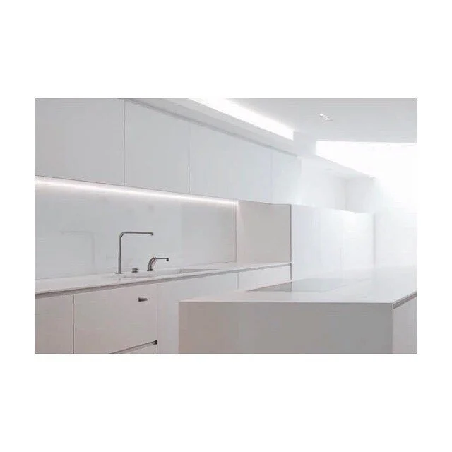 White corian kitchen with recessed strip lighting makes this basement feel bright and airy #kitchen #kitchendesign #white #whitekitchen