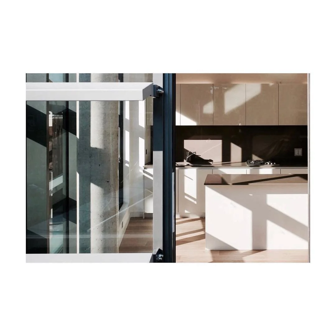 Floor to ceiling glass walls with fins on the facade that cast interesting shadows on this minimal kitchen #shadows #facade #kitchen #light #cast