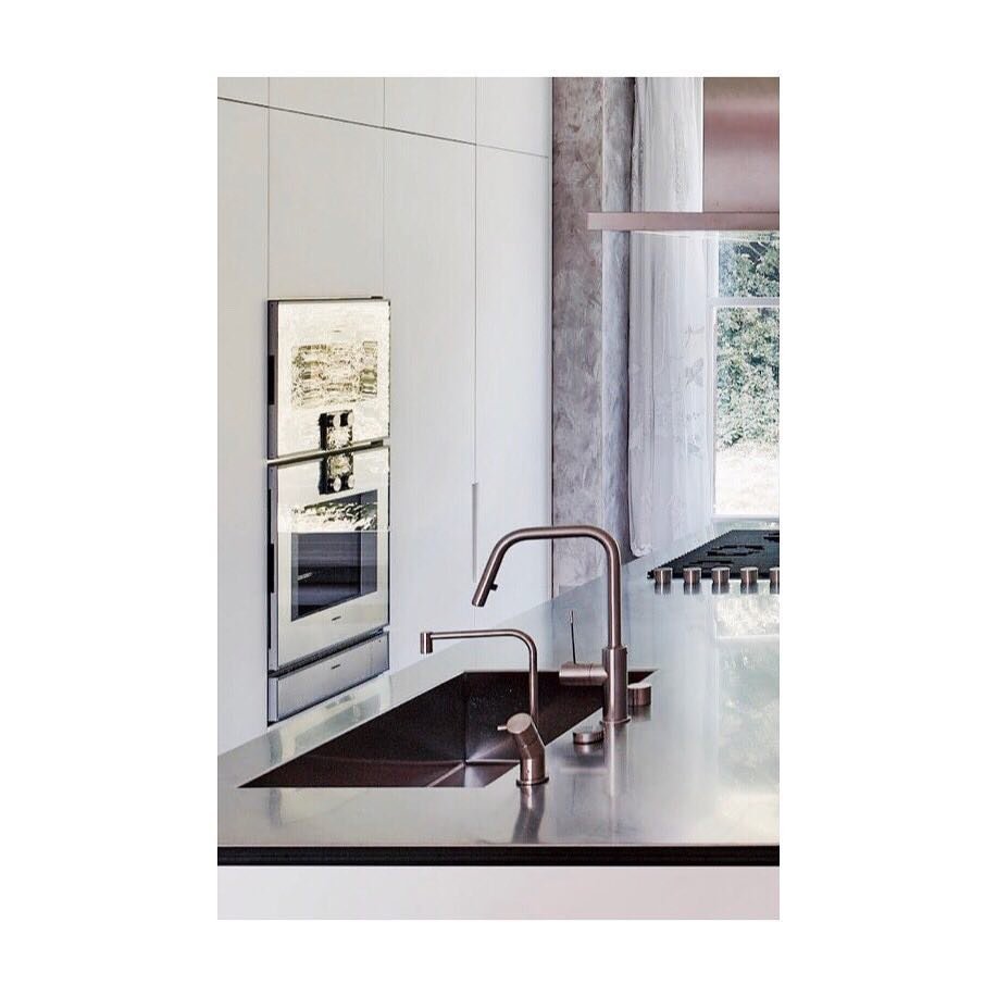 White kitchen designed to disappear into the wall with stainless steel island by @boffi_uk #kitchen #kitchenisland #boffi #hidden