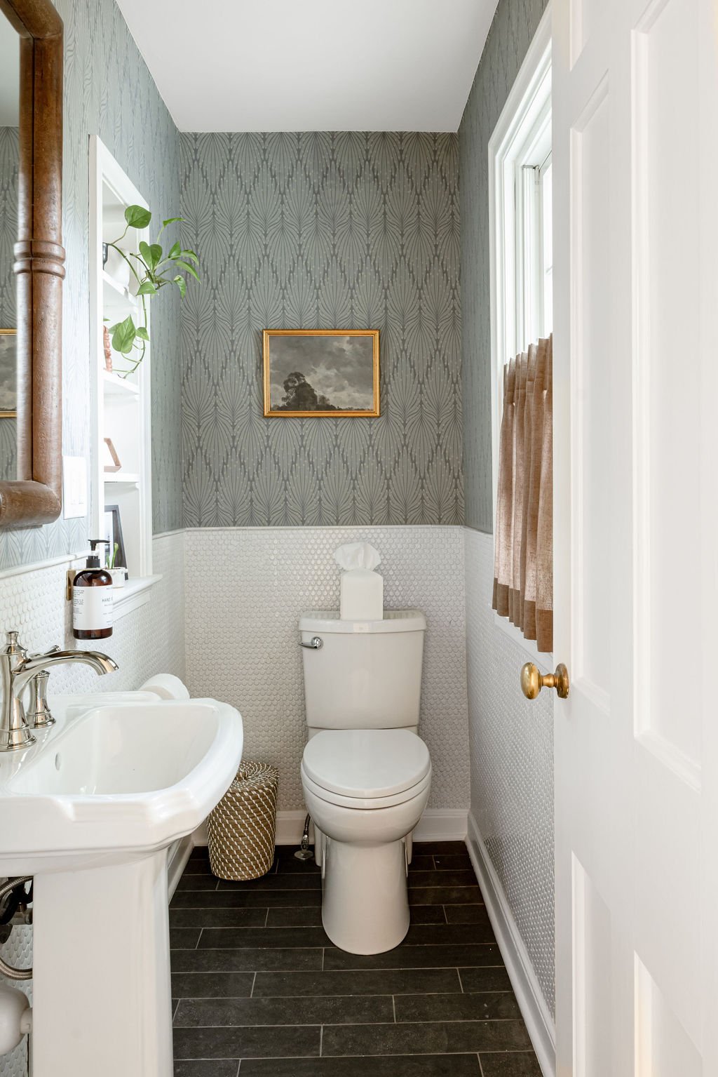 Compact powder bath renovation with wallpaper, tile and classic finishes.
