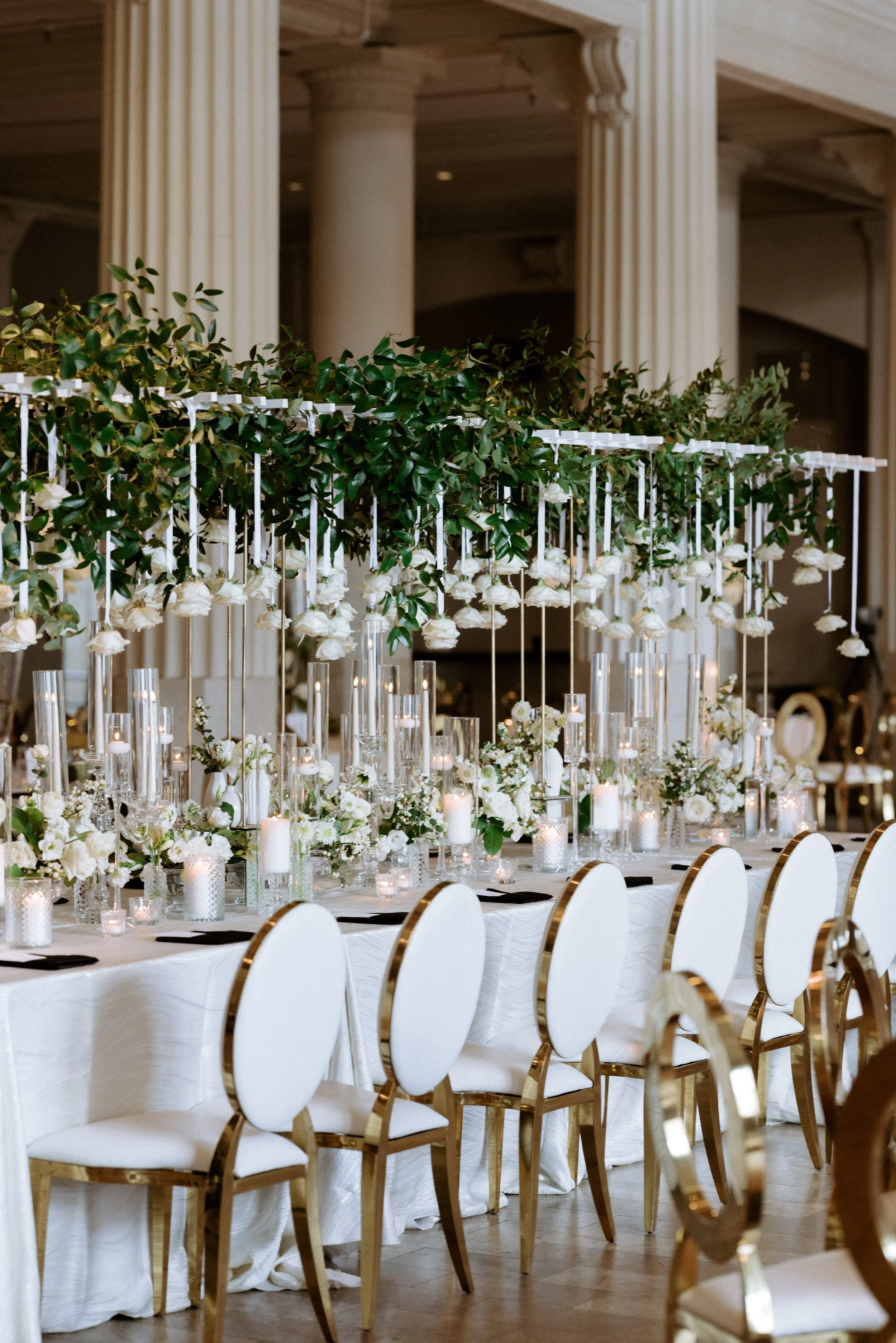 A cascading installation of roses suspended above the head table at The Corinthian Houston — lush, dramatic, and utterly show-stopping. This overhead floral moment creates an intimate canopy of blooms that frames the wedding party in pure romance.